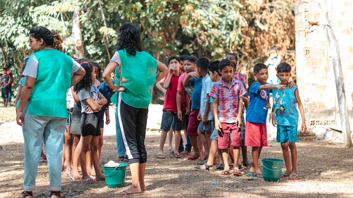 people in green shirts standing on brown soil during daytime